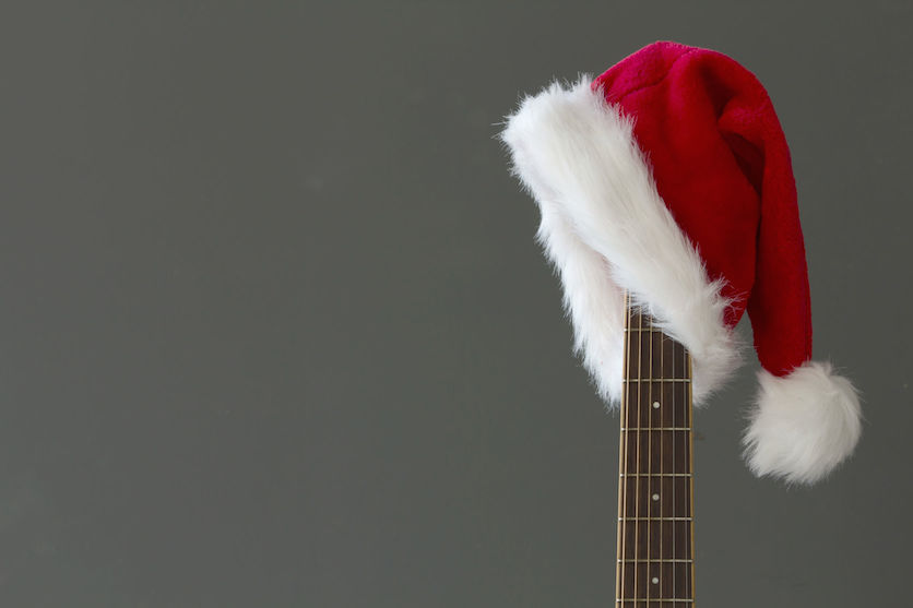47435811 – red christmas hat on guitar with grey background, merry christmas